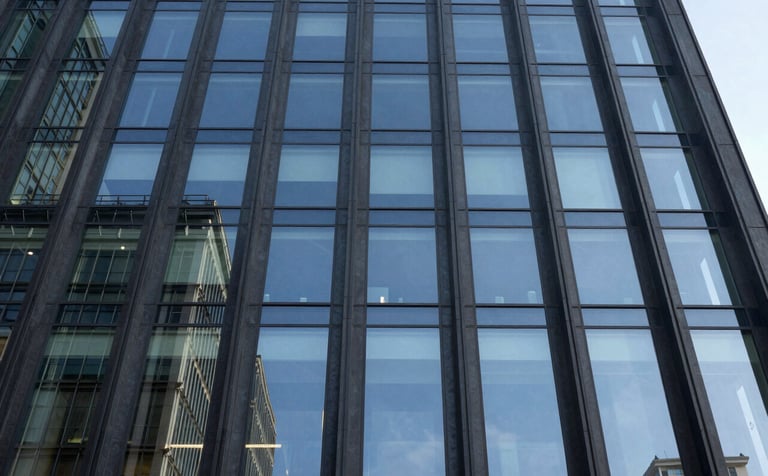 A low-angle architectural photograph of a modern glass office building facade reflecting a clear sky. The image features deep slate blue glass and dark charcoal steel frames, conveying a sense of legal authority and corporate stability.