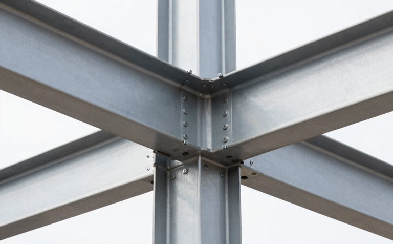 Close-up of a high-complexity structural joint in a modern steel building, visible precision welding and heavy bolts, industrial minimalist aesthetic, Silver Gray steel against a White backdrop, North American / Mexican construction site, sharp clean lines.