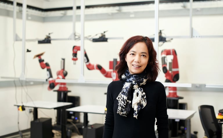 a woman in a black dress standing in a room with a bunch of tools