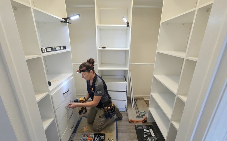 Professional closet installer assembling a custom white walk-in closet system with drawers