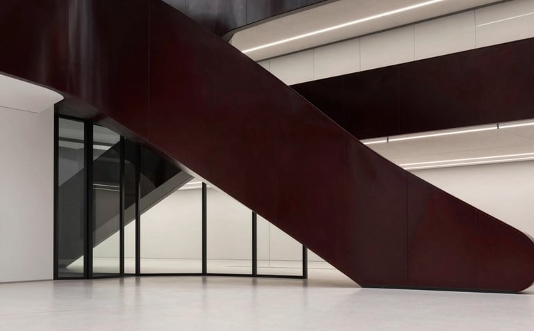 A sharp, sophisticated architectural interior featuring abstract glass and steel geometries. The color palette is black, deep red, and off-white. The lighting is crisp, emphasizing clean, Apple-inspired aesthetics for a visionary agency.