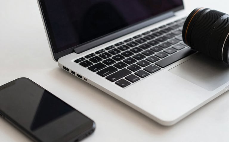 A close-up of a professional desk setup featuring a sleek laptop and a smartphone. The scene is clean and sophisticated, using a palette of dark navy and cool off-white to emphasize a forward-thinking, digital-first agency.