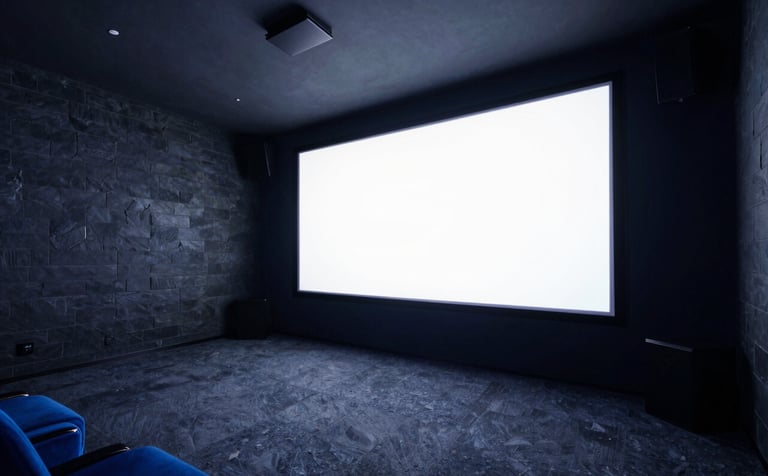 Wide-angle photograph of a sophisticated home cinema room with dark slate walls and ambient electric indigo lighting, featuring a huge screen with 4K clarity.