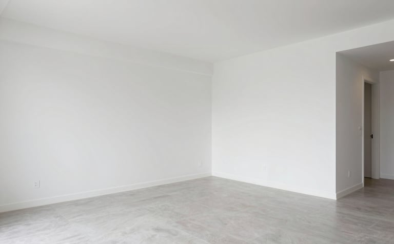 An interior shot of a newly renovated luxury apartment. The space features clean white walls, light gray porcelain tile flooring, and modern lighting. The aesthetic is professional and reflects high-quality European standards.