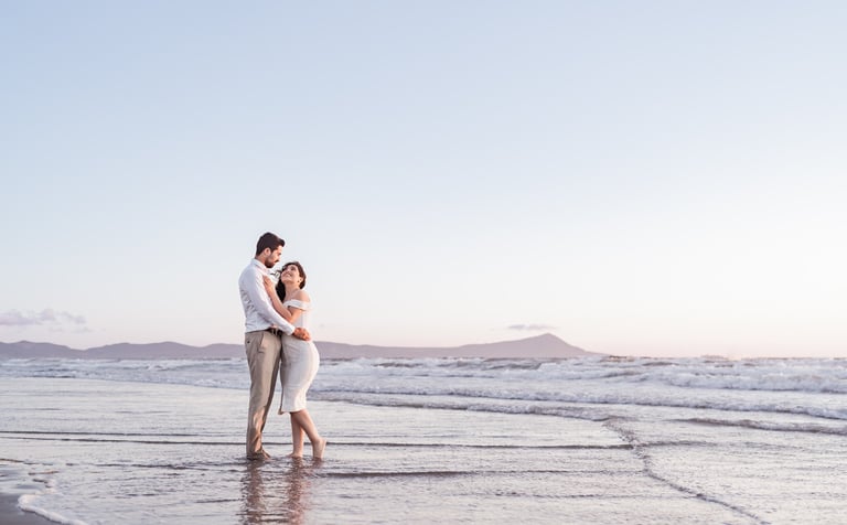 a man and woman standing in the ocean