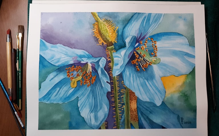 a watercolor painting of a blue hyacinth on a table with paintbrushes next to the painting