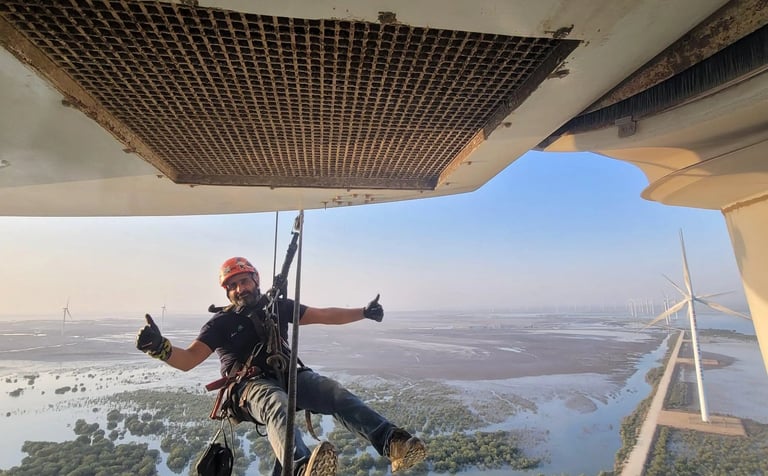 a man is hanging from a helicopter while he is hanging from a rope