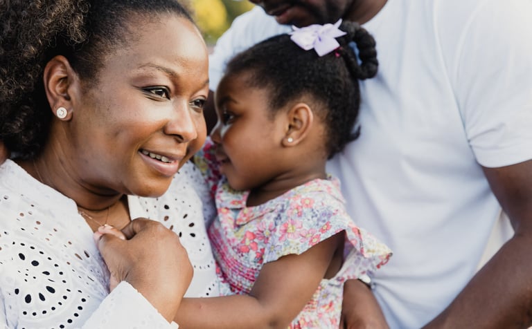 a woman holding a toddler and smiling 