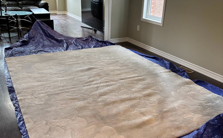White rug on protective tarp: Professional in-home rug cleaning for ultimate convenience & safety.
