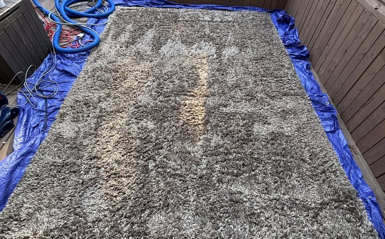Gray rug on patio during deep cleaning. Outdoor rug cleaning for your convenience.