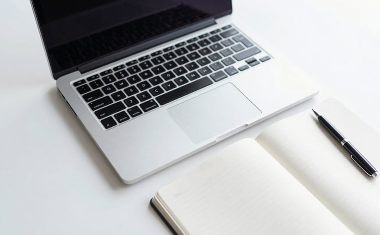 A minimalist and professional top-down shot of a clean office desk featuring a high-end laptop, a white notebook, and a sleek pen. The scene is bathed in natural morning light, using a palette of #F7FAFC and #A0AEC0 to emphasize efficiency and modern business standards.