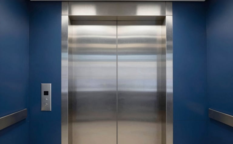 A sleek, modern elevator interior with brushed steel doors in a professional East African / Mozambican office building. The lighting is crisp and clean, reflecting a trustworthy and innovative engineering brand. Colors include midnight blue and pale mist gray.