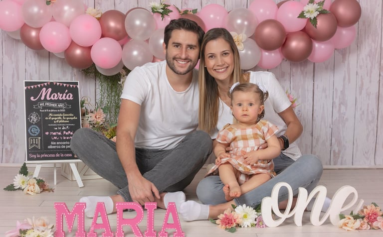 a man and woman sitting on a floor with balloons