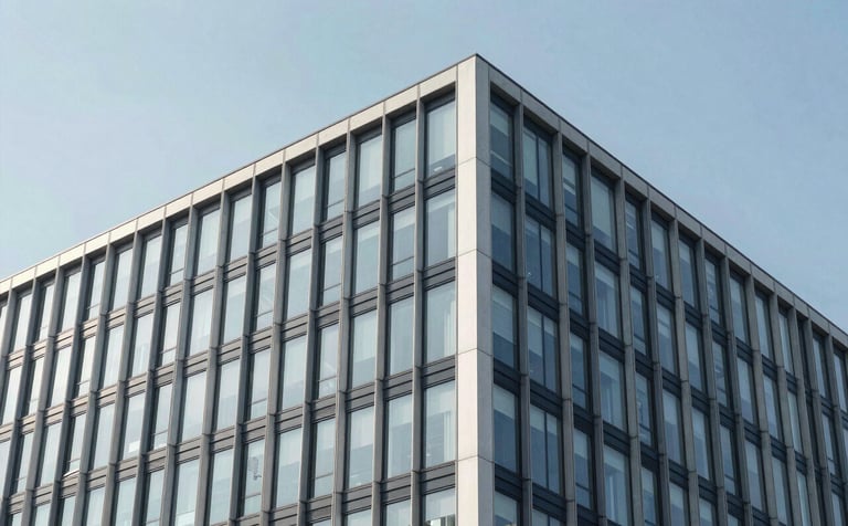A crisp architectural photograph of a modern steel and glass building facade against a sky blue sky. Mist white and midnight navy architectural details are visible.