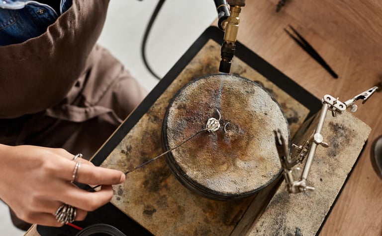 Joyero utilizando un soplete de butano para soldar un anillo de plata hecho a mano