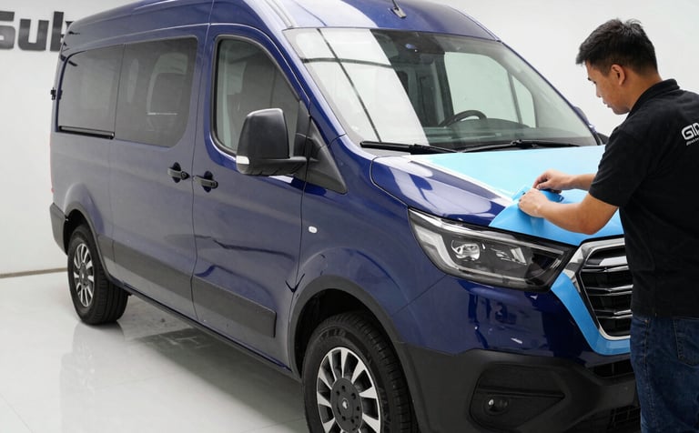 Professional technicians applying high-quality vinyl wrapping to a corporate vehicle in a clean, bright bay, Sul Americano industrial setting, sharp focus on the application process, vibrant textures, midnight blue and light sky blue accents.