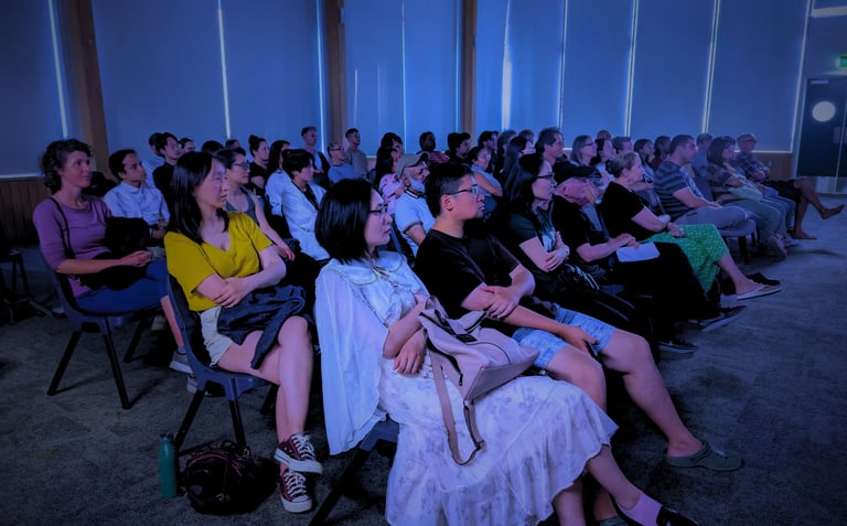 Diverse audience enjoying a cozy film screening at Auckland International Film Club.