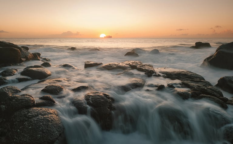 Sunrise over ocean waves on rocky shores in Albion, Mauritius