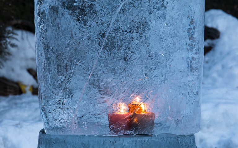 Bougie allumée figée dans la glace, symbole de mémoire et d’introspection hivernale.