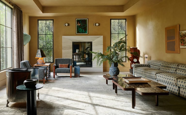 Kelly Wearstler living room with a couch and a table and large fireplace.