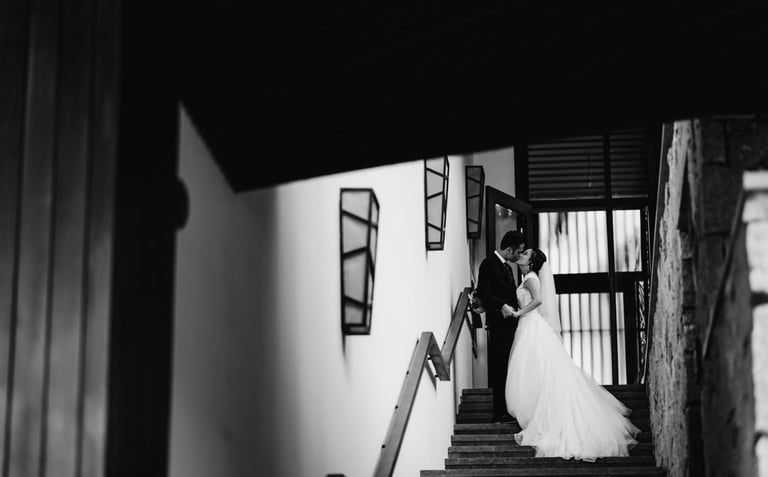 a bride and groom standing on stairs in a black and white photo