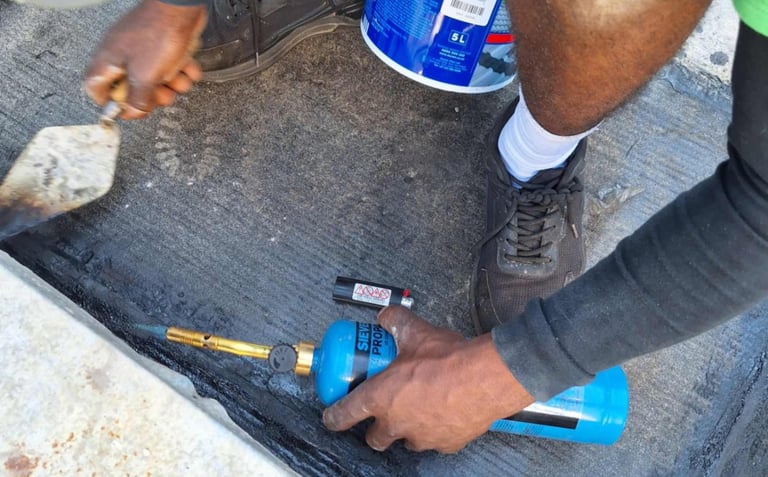 Setting of torch on bitumen with troweling tool, Scottburgh Mall, South Coast, Amanzimtoti