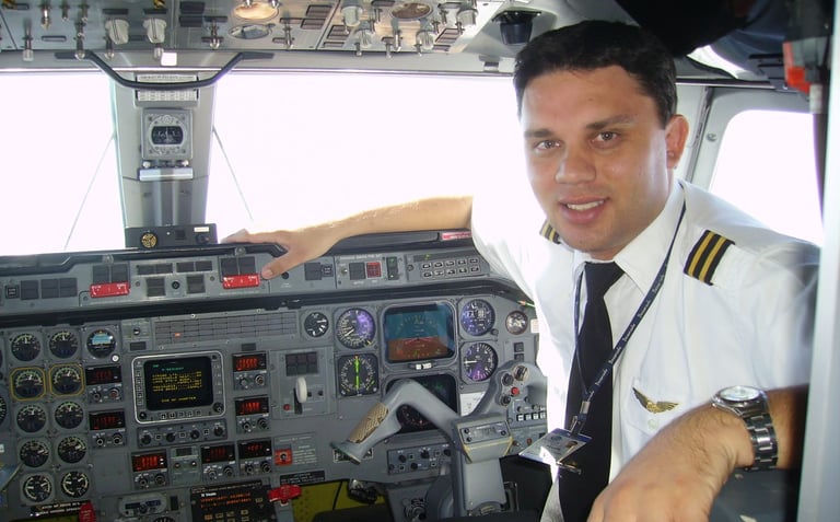 a man in uniform is sitting in a plane. flightdeck do emb120 embraer brasilia