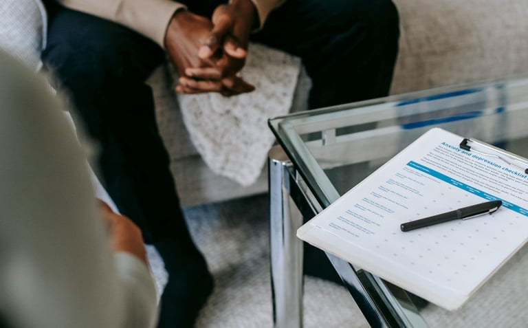 A calm therapy office setting in Calgary with an open notebook on a small table between two chairs,