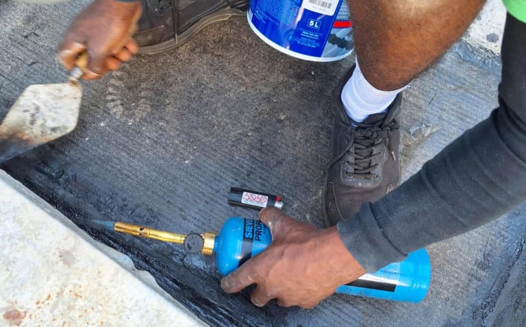 Setting of torch on bitumen with troweling tool, Scottburgh Mall, South Coast, Amanzimtoti