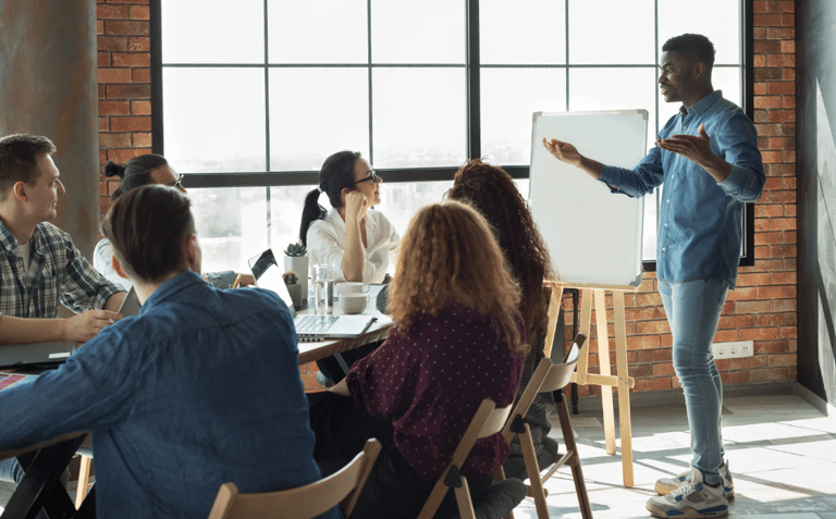 Man presenting to a team in a conference room, representing personal leadership & active engagement.