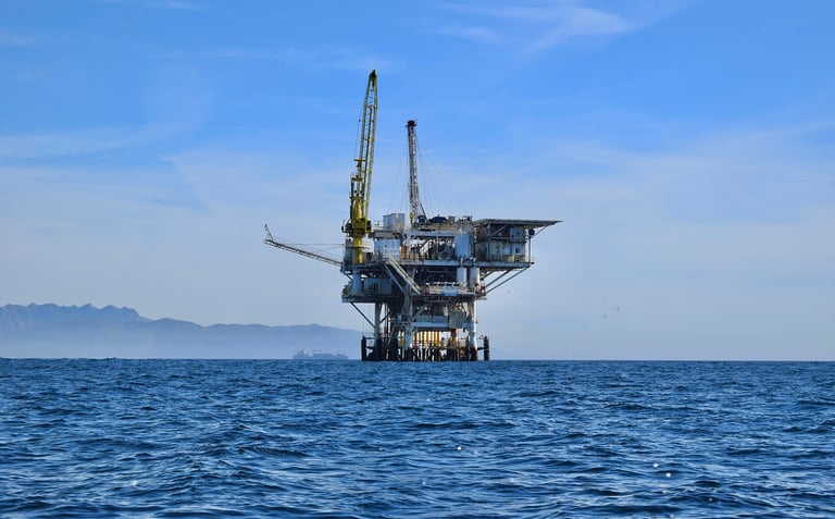 a large oil rig with a crane in the middle of the ocean