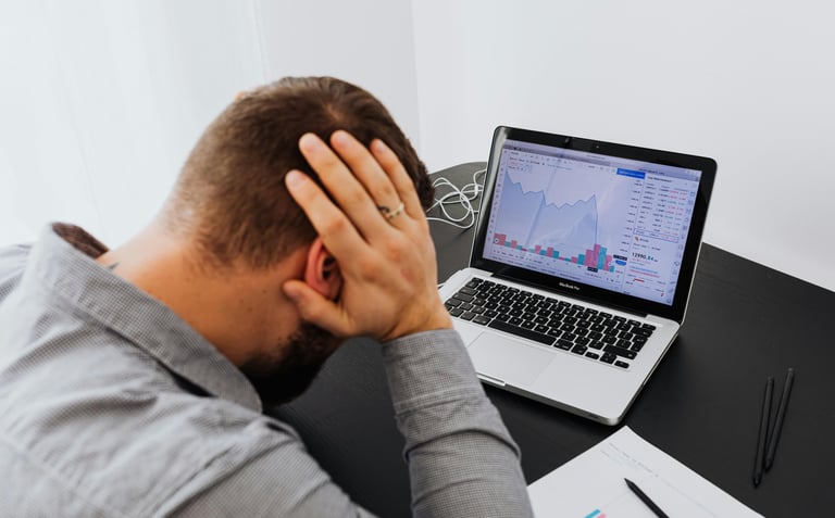 Empresário preocupado analisando relatórios financeiros, representando os custos invisíveis que redu