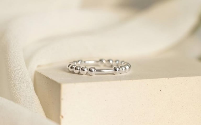 a ring with a diamond ring on top of a white surface
