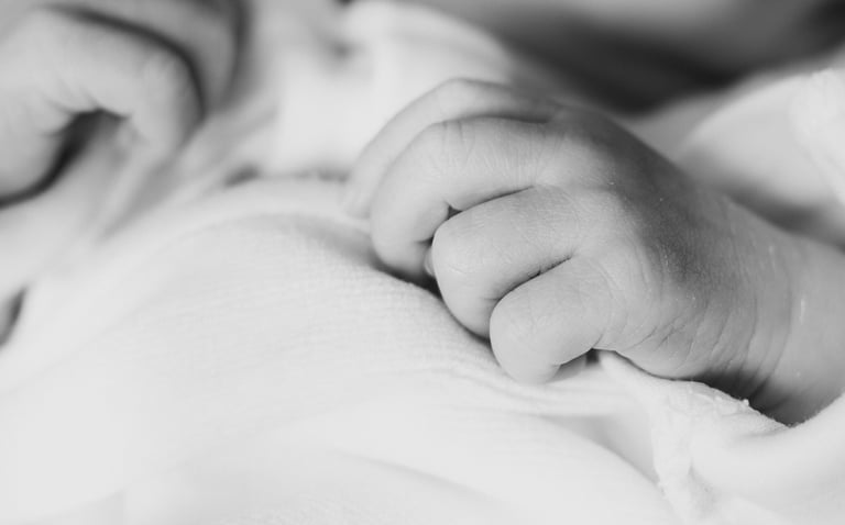 a baby's hand on a blanket