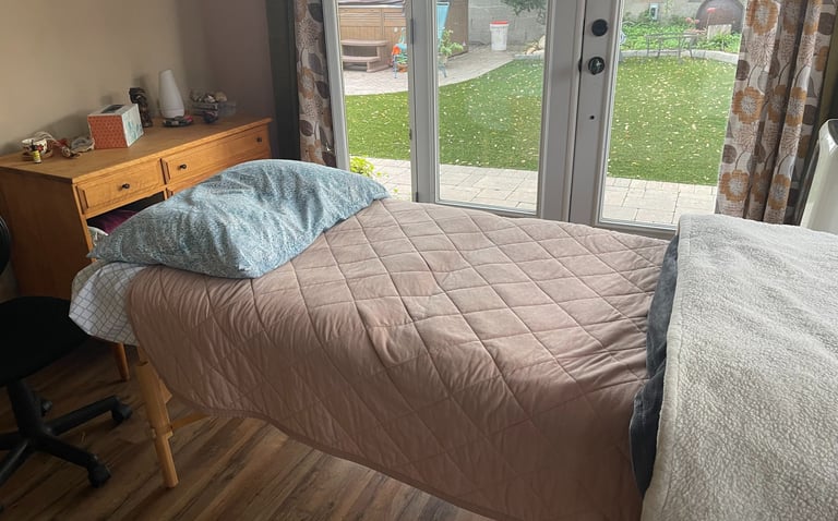 Massage table with pink blanket in a treatment room