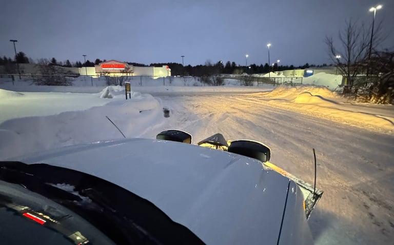 A plow truck finishing plowing a parking lot