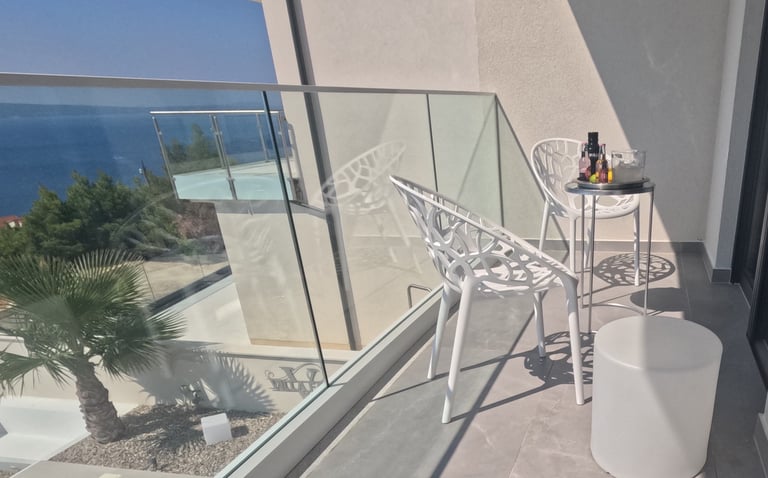 Villa Fay balcony with a table and chairs and a bottle of wine