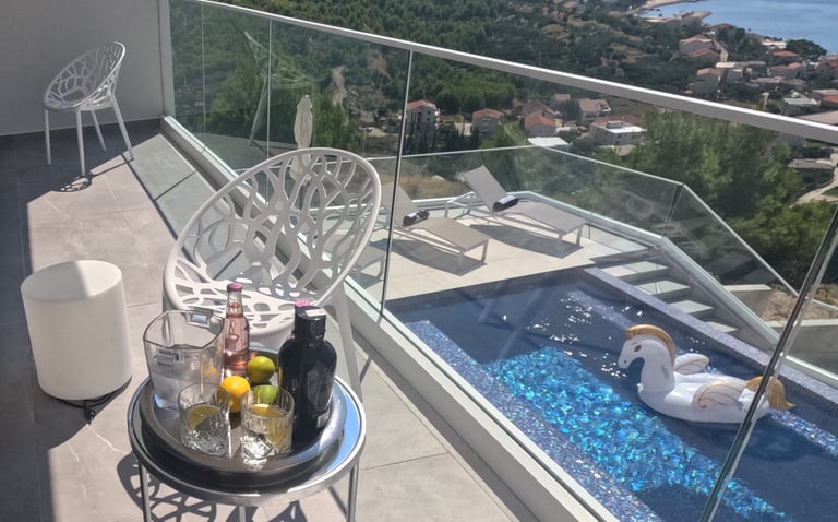 Villa Fay balcony with a table with a tray of drinks and a swan in the pool