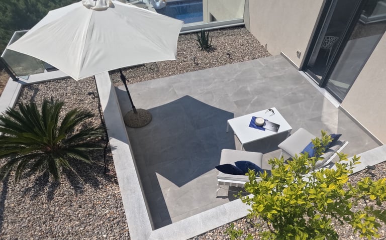 Villa Fay terrace with a table and chairs and umbrellas