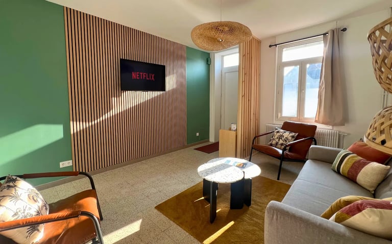 Salon moderne avec TV connectée et canapé, hébergement professionnel tout confort