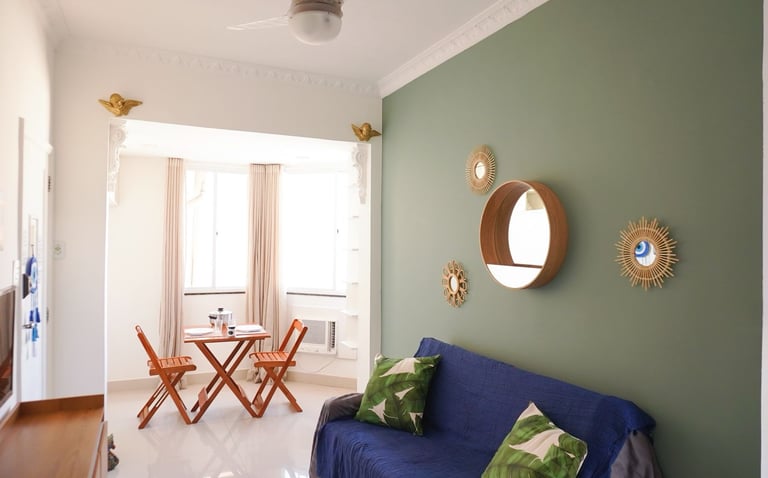 a couch with pillows and a table with chairs