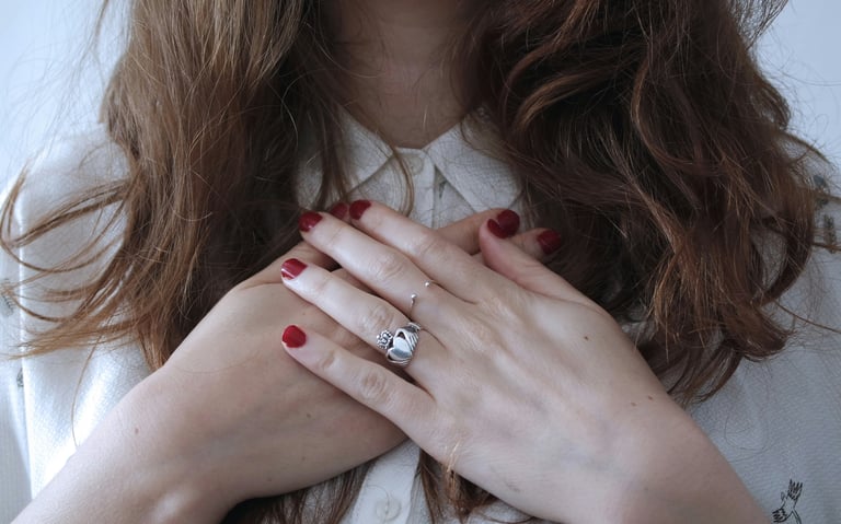 a woman with red nails with her hands on heart