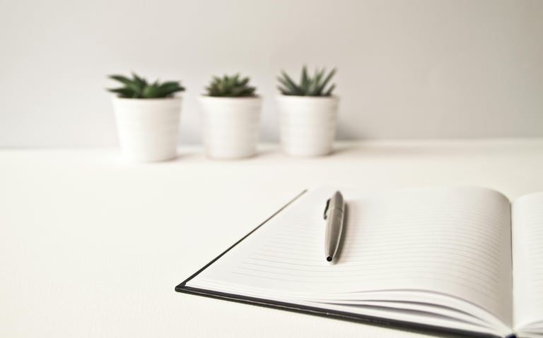 Notitieboekje met pen, klaar voor persoonlijke reflectie en het vastleggen van één vraag per overleg