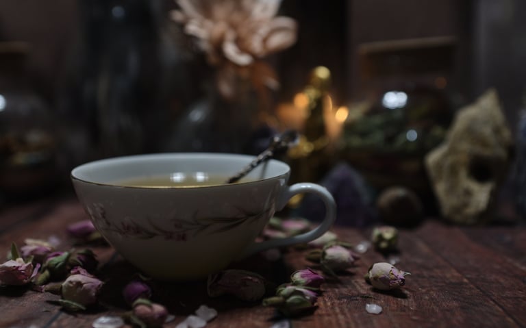 a cup of tea surrounded in dried pink roses