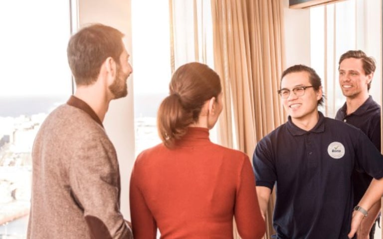 a group of people standing around a mirror