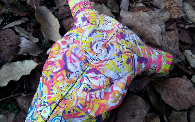 peinture aux couleurs vives sur un crane  sur un lit de feuilles mortes