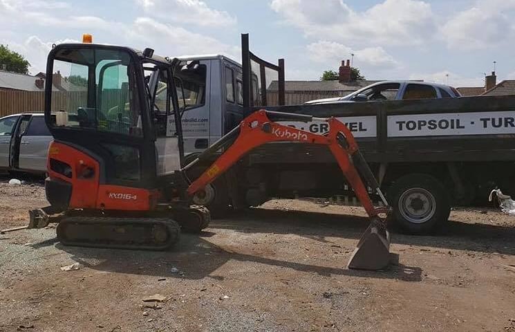 mini digger parked in front of a pickup truck in halesowen