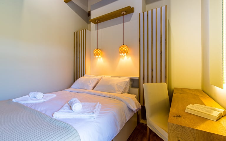 Stylish double bedroom with wooden ceiling and natural light at Villa Skyphos, Crete