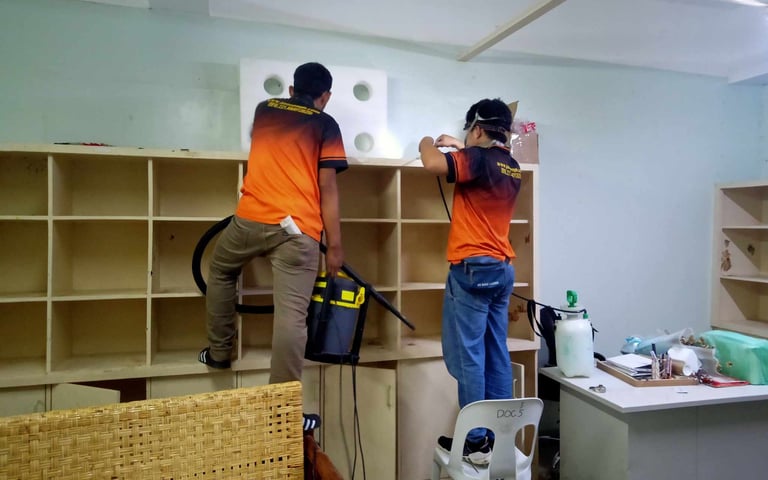 Professional pest control technicians inspecting supermarket shelve using specialized tools.