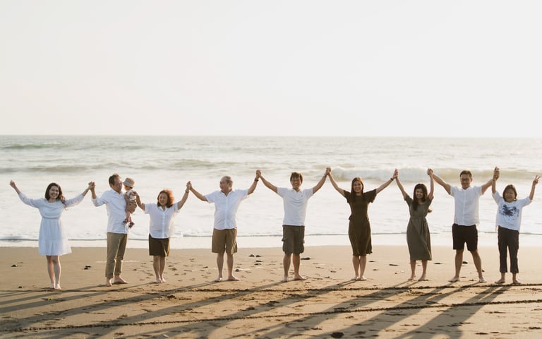Large multi generation family standing together on Nyanyi Beach in Tabanan Bali during a sunset family photography session